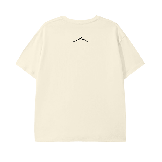 ack view of the Piste Out Logo Tee in cream, featuring the minimalist black mountain line graphic below the neckline on a light brown cotton shirt. Clean, ski-inspired design from Colorado brand Piste Out.