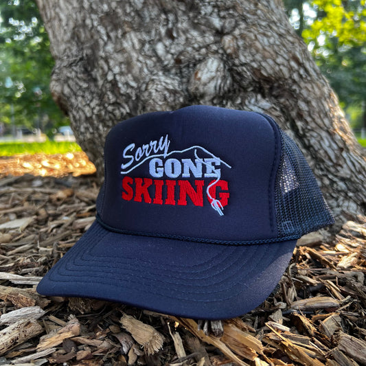 Blue square variant of the Sorry Gone Skiing Trucker hat outdoors
