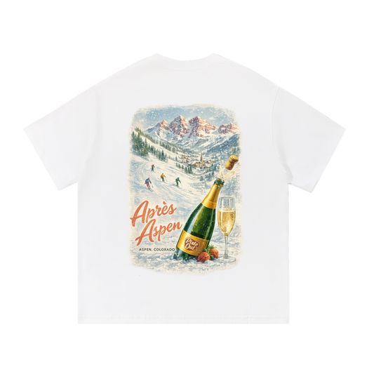 Snow white Après Aspen ski tee back graphic featuring vintage Maroon Bells ski poster scene with champagne bottle and skiers.