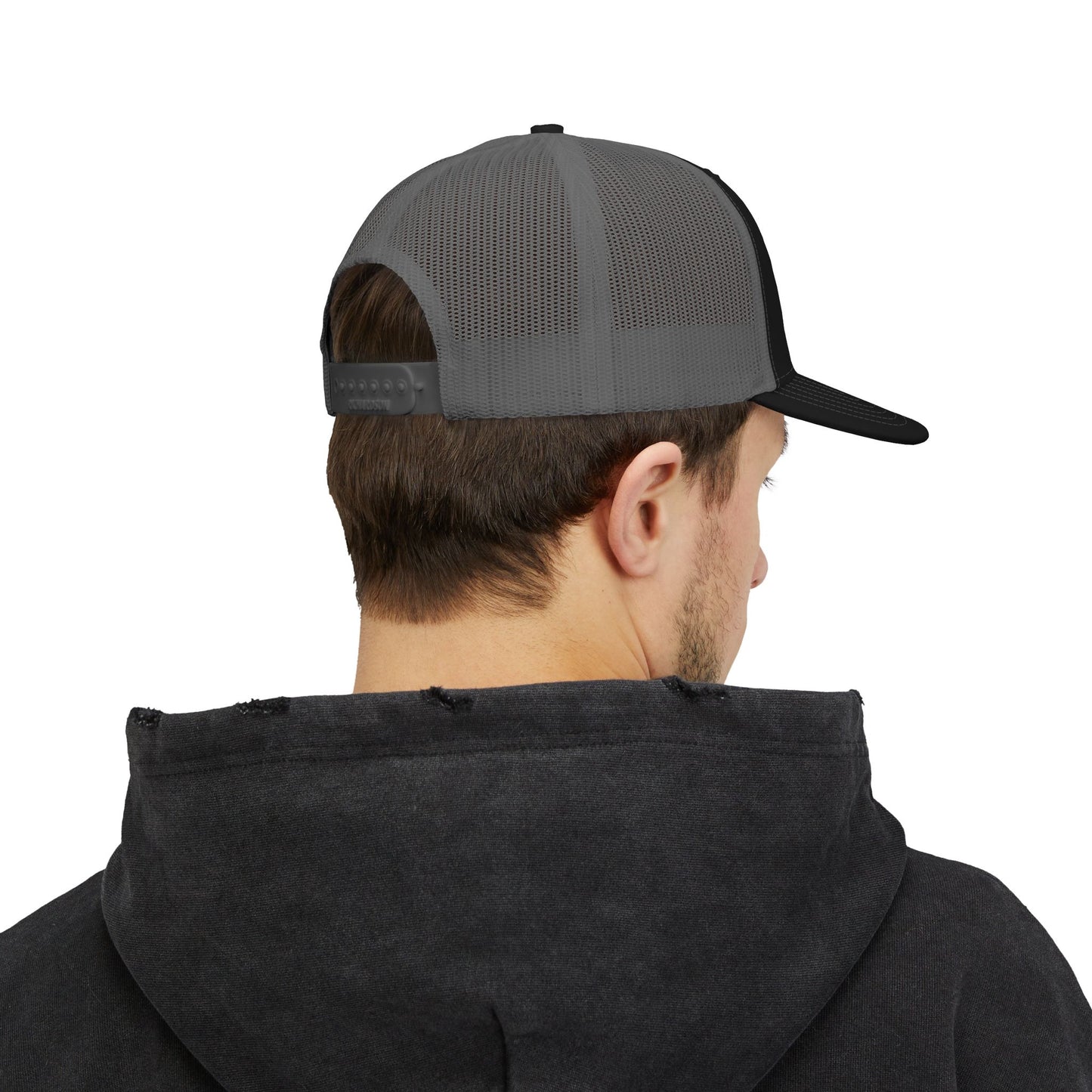 Rear angle of black and grey trucker hat worn by model, showing mesh back and snapback closure