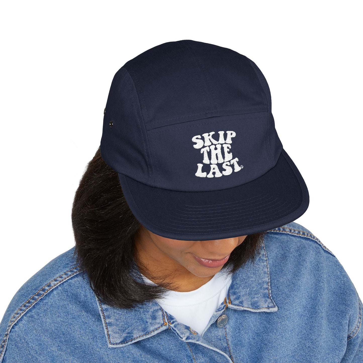 Navy blue Skip the Last 5-panel hat worn by model, front embroidery visible.