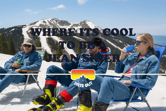 Three skiers in denim relax on a snowy mountain, drinking canned beers with spring ski slopes in the background.