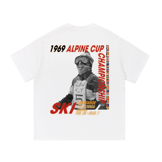 Snow 69’ Alpine Classic tee back view featuring vintage alpine poster graphic with skier photo and flag border.