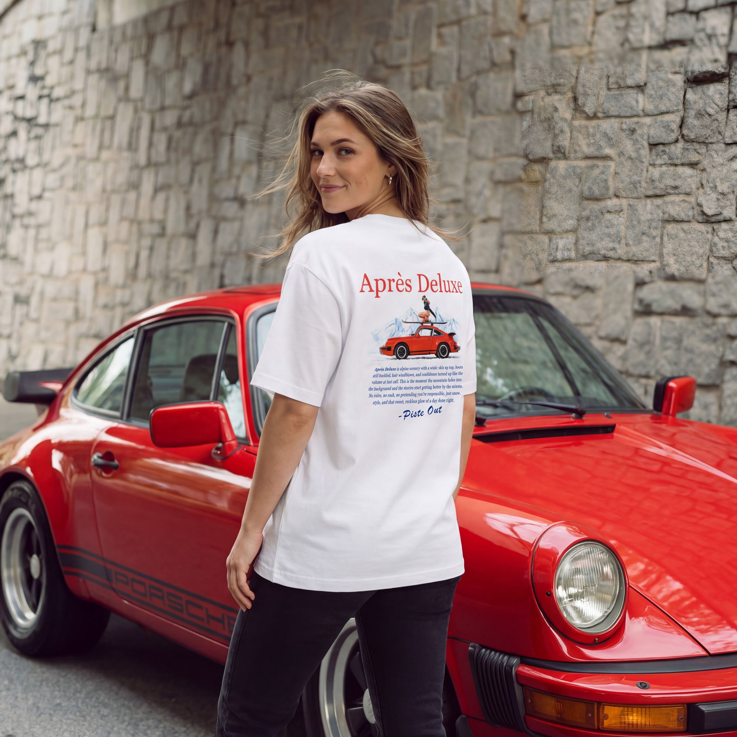Back model shot of Snow Après Deluxe tee with large mid-back red “Après Deluxe” text and red car graphic with skier on skis.