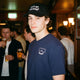 Male model wearing the Blue Square logo lines tee and Lets go Skiing hat in a bar. 