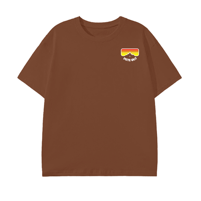 Front view of Piste Out Logo Tee in Caramel Macchiato color, featuring the retro ski goggle logo on warm brown cotton.