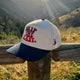 Golden hour shot of the blue square Skip the Last Hat outdoors. 