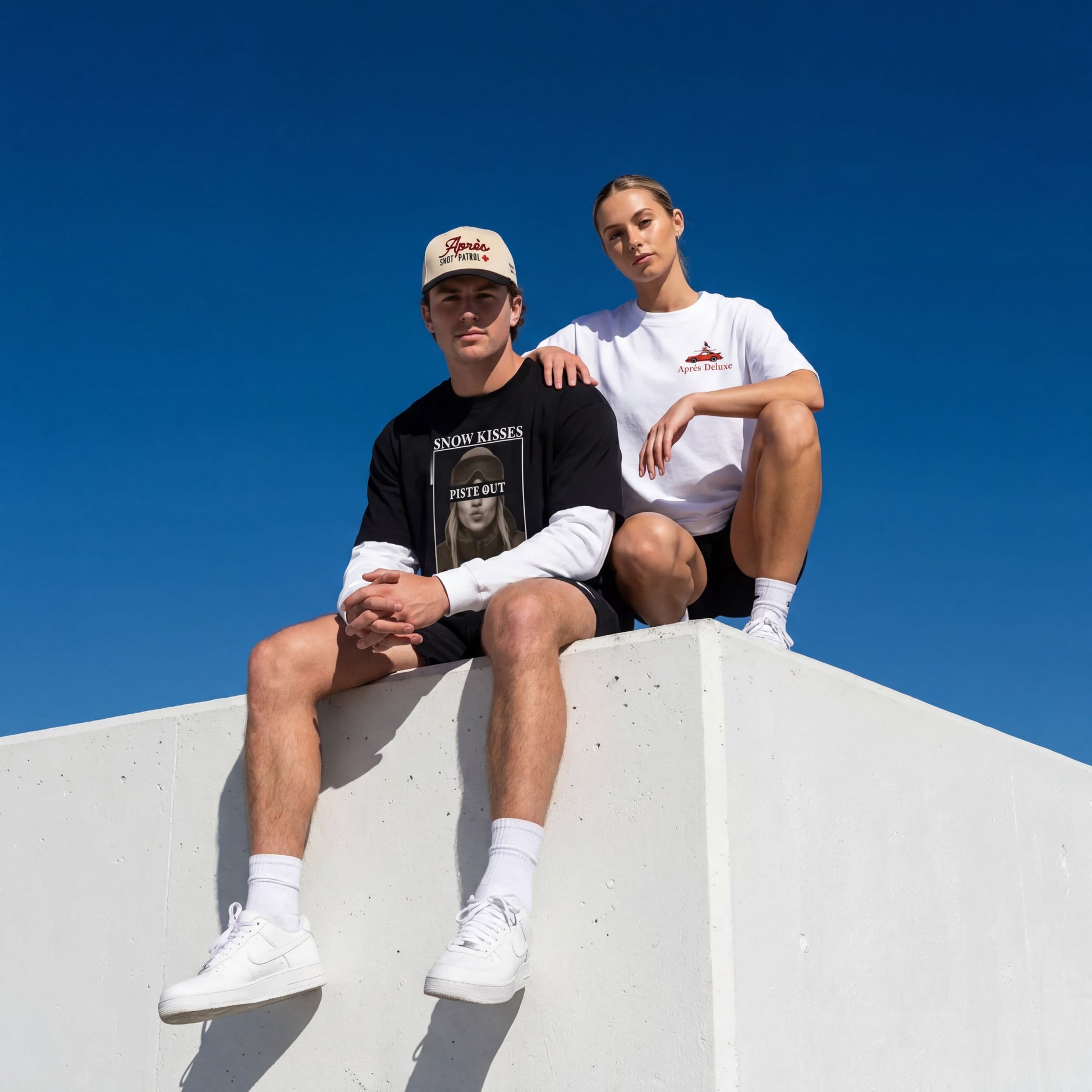 Male model wearing the apres shot patrol and Snow Kisses tee and female model wearing the apres deluxe tee. 
