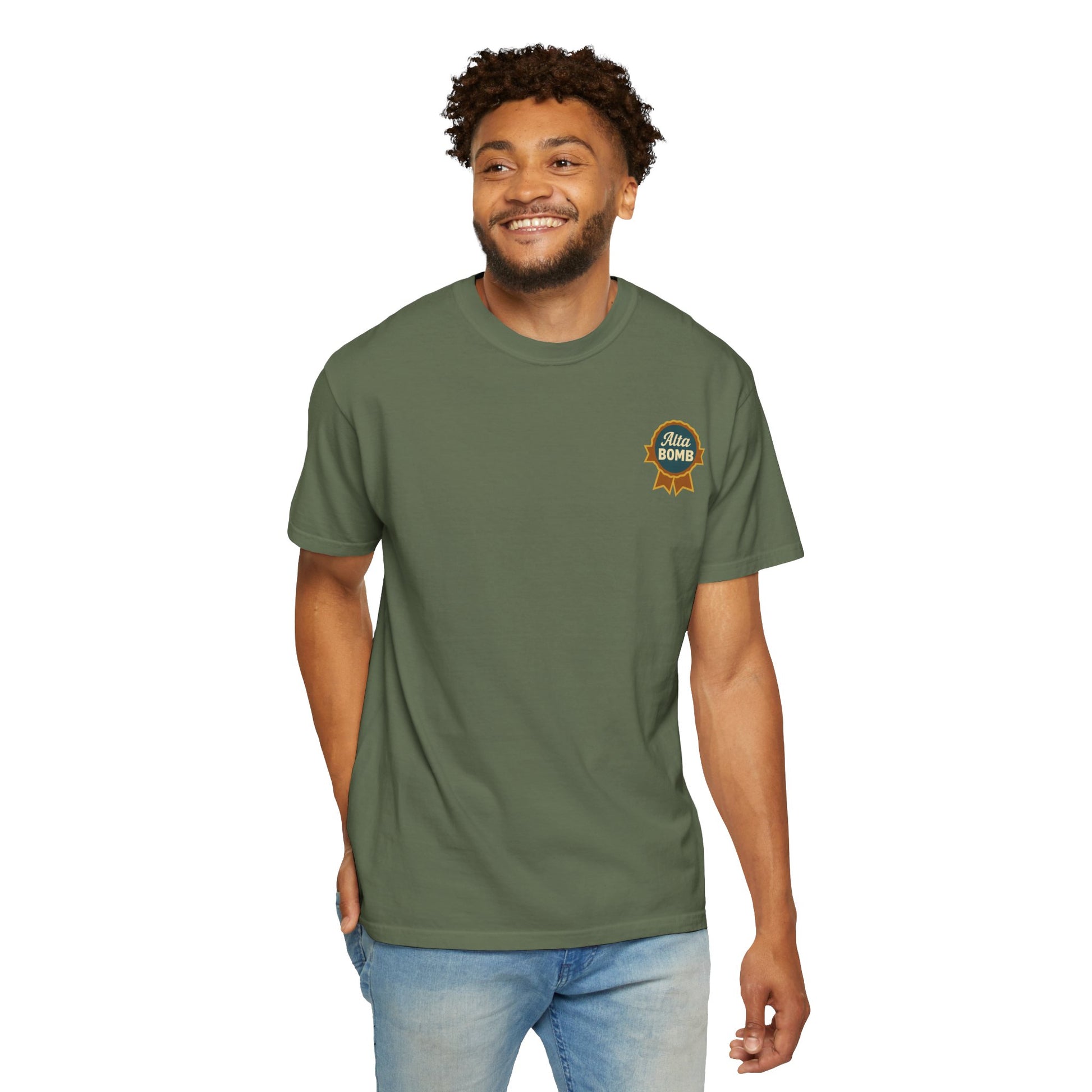 Model wearing green Alta Bomb t-shirt showing small chest ribbon badge.