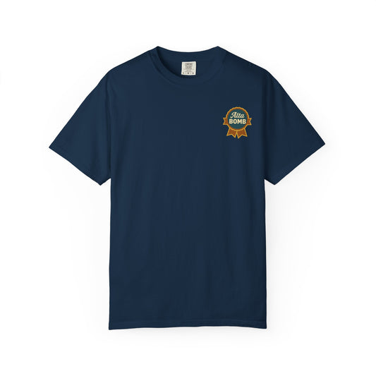 Flat lay of navy Alta Bomb t-shirt with small ribbon badge chest design.