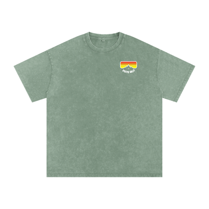 Front view of green circle American Gaper tee with small Piste Out goggle logo on the left chest.