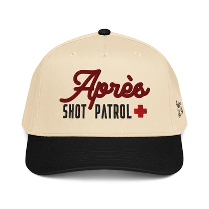 Front view of the cream and black Après Shot Patrol hat showing the main embroidery on the front