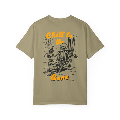 Back of khaki tee featuring laid-back skeleton with skis, beer, and bold “Chill to the Bone” graphic