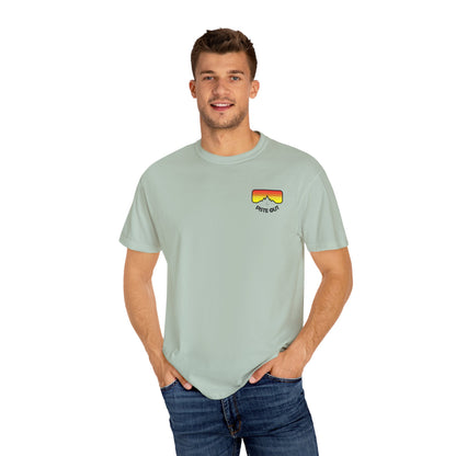 Model wearing sage green tee, front view with chest goggles logo