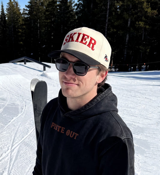 Male model wearing the Skier hat in black diamond and sun glasses on a ski slope.