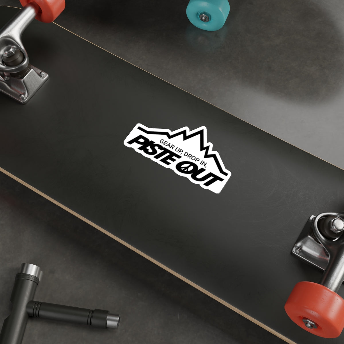 Sticker applied to skateboard deck, displaying iconic black Piste Out mountain design and peace-themed logo