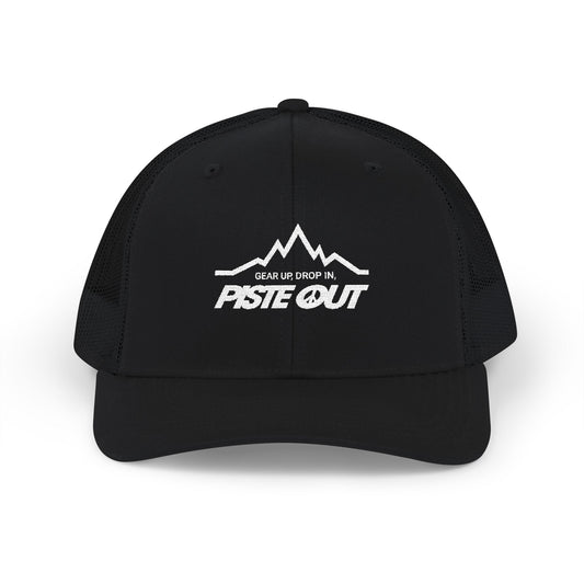 Front view of black trucker hat with white Piste Out mountain logo and slogan “Gear Up. Drop In.” embroidered on front