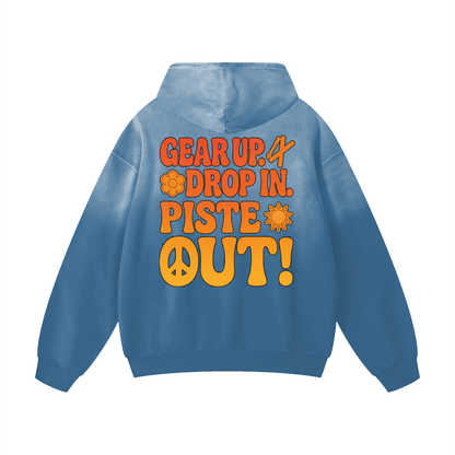 Back view of Blue Square Piste Manifesto Hoodie featuring “Gear Up. Drop In. Piste Out!” slogan in orange and yellow with vintage ski vibe.