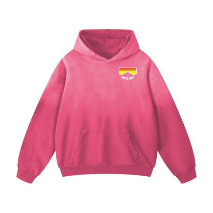 Front view of pink Piste Manifesto Hoodie with small retro goggle logo on chest and sun-faded wash.