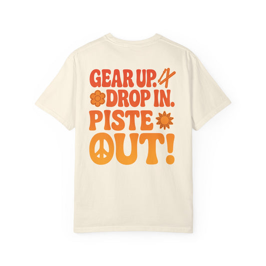 Back of cream tee with large retro orange “Gear Up. Drop In. Piste Out!” slogan print
