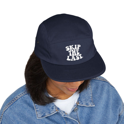 Navy blue Skip the Last 5-panel hat worn by model, front embroidery visible.