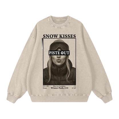 Front view of light apricot Snow Kisses vintage crewneck featuring ski town crush graphic and Piste Out logo across goggles.