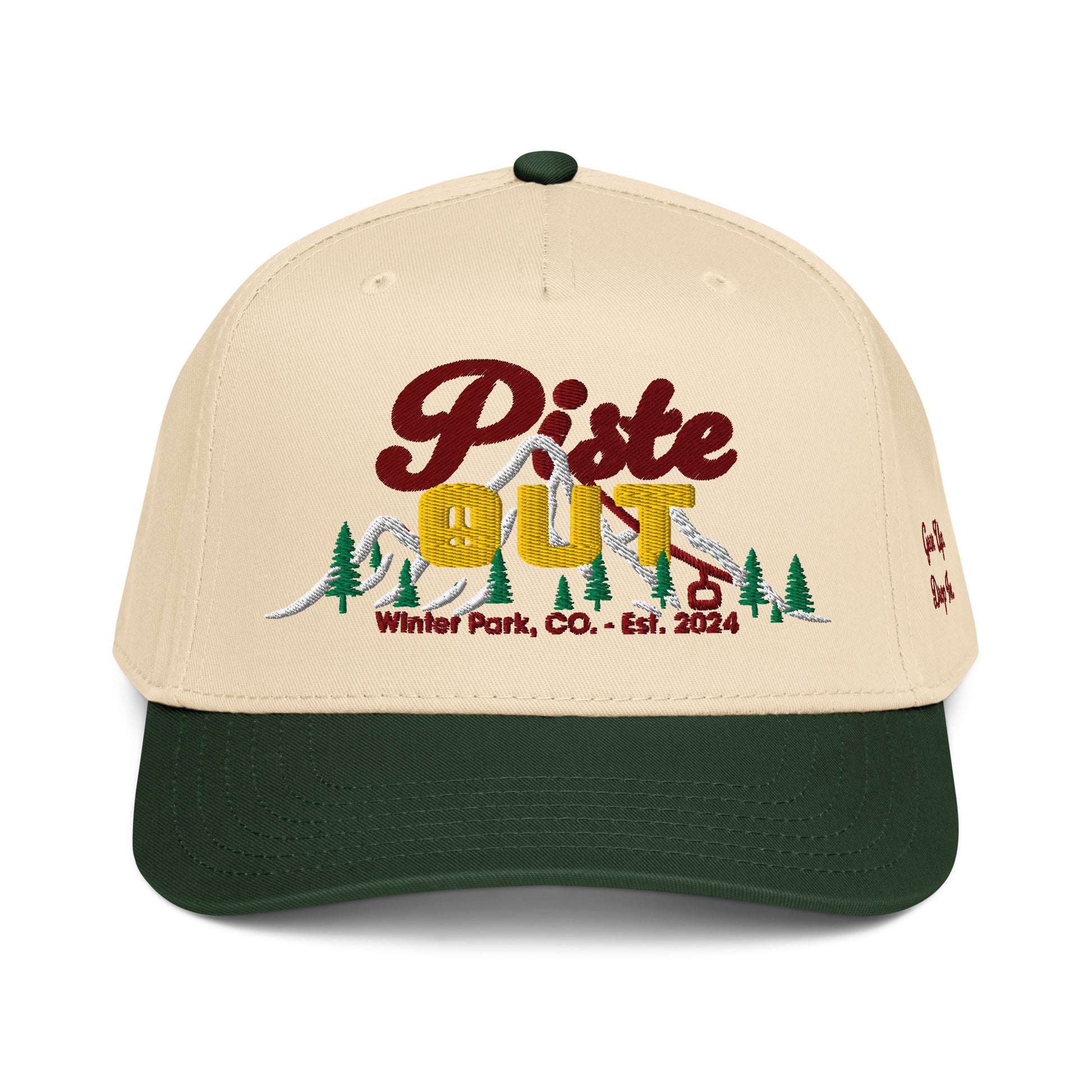 Front view of cream and forest green Sunset Hat featuring embroidered Piste Out logo with sunset gradient text and ski lift design, Winter Park CO Est. 2024.